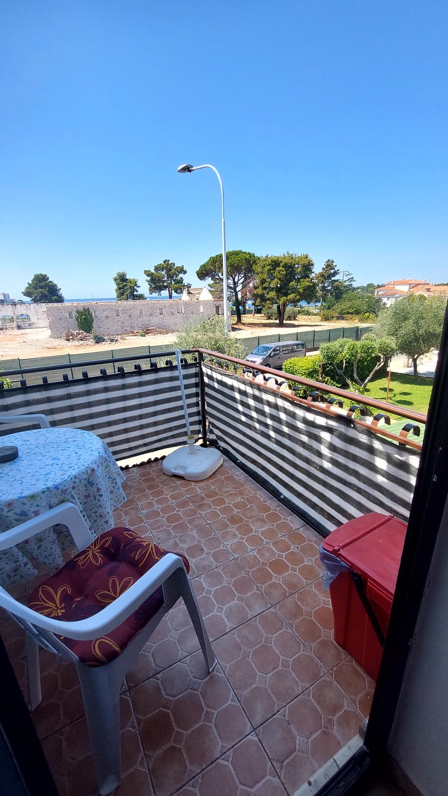Balkon sa stolom i stolicama te pogledom prema moru i zelenilu