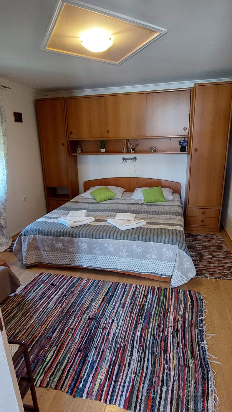 Spavaća soba s bračnim krevetom i zelenim jastucima